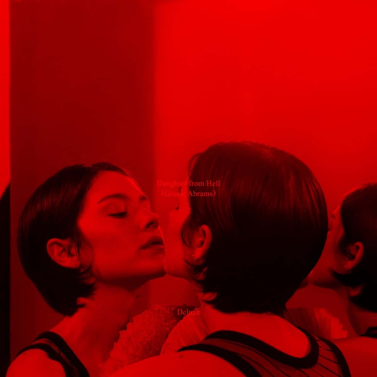 Portada oficial de «Daughter From Hell (Deluxe)», de Gracie Abrams: dos reflejos de la cantante, de pelo corto oscuro, casi rozándose la cara frente a un espejo, todo bañado en luz roja