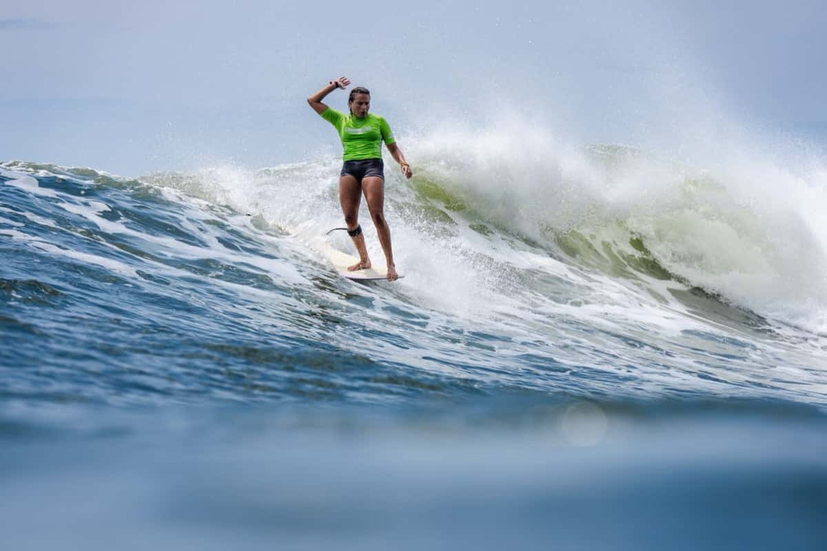 Alice Lemoigne, con lycra verde, camina sobre su longboard con un brazo en alto en una ola de El Sunzal, en la quinta jornada del Mundial, el miércoles 21